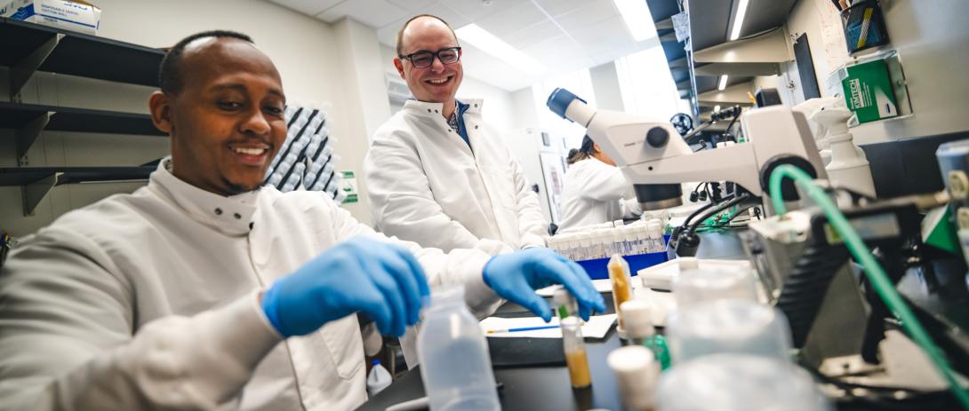 Dylan Shropshire with Alphaxand Kaimba Njogu working in their lab.